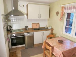 une cuisine avec une table, un évier et une cuisinière dans l'établissement Villa Roma, à Losheim 2 autres photos