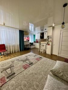 un soggiorno con un letto e una cucina di Studio Apartment Center a Kremenčuk