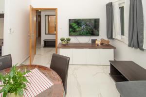 a living room with a table and a tv on the wall at Villa Valencan 1 in Vodnjan