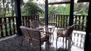 a porch with chairs and a table on a balcony at Chez B&S Linares in Celep +18 photos