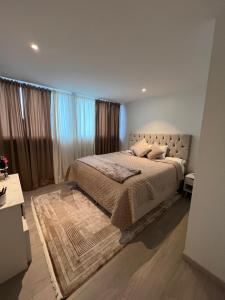 a bedroom with a large bed with curtains and a rug at Leilighet i trondheim in Trondheim