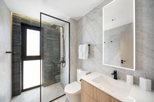 Un baño con lavabo, inodoro y ducha. en Allure 205 apts, en Bridgetown