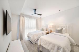 Un dormitorio blanco con dos camas y una ventana. en Allure 205 apts, en Bridgetown 19 fotos más