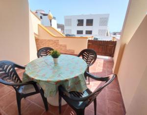 a table on a balcony with a potted plant on it at Mafasca, comodo e silenzioso, terrazza e cortile, WI-Fi in Morro del Jable