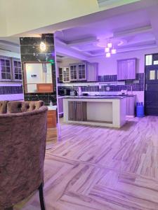 a large kitchen with wooden floors and purple lighting at Exquisite 6 bedroom Villa in Nakuru in Nakuru