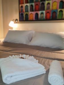 2 letti con asciugamani bianchi sopra di 4Rooms Guest House Free Wi-Fi a Salerno