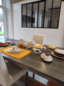 una mesa con comida y bebidas. en Le clos des Prêles, en Boismont