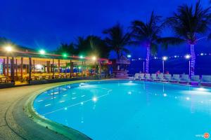 a swimming pool in front of a hotel at night at Coral Resort & Bungalows in Haad Rin