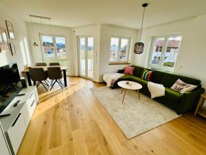a living room with a green couch and a table at Wildes Wohnen in Peiting