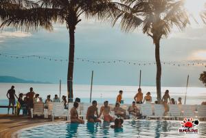a group of people sitting in a swimming pool on the beach at Coral Resort & Bungalows in Haad Rin