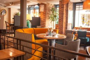a restaurant with yellow chairs and tables and a table at Le Franklin in Paris