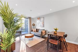 a living room with a table and a couch at Synergy Bloom Nine Elms in London