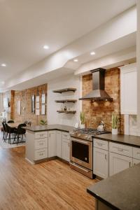 a kitchen with white cabinets and a stove top oven at Stunning 4BR Townhome Rooftop City Views in Cincinnati