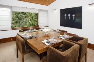 Aberdeen Premium Stay في كامبوس دو جورداو: غرفة طعام مع طاولة وكراسي خشبية