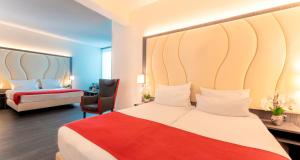 a hotel room with a bed and a chair at PLAZA Premium Almere in Almere
