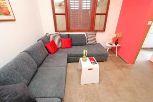 a living room with a gray couch and red pillows at Holiday Home Marco's Place in Vela Luka