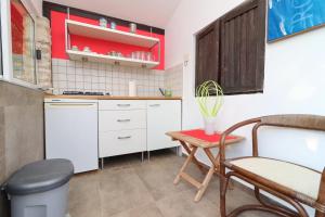 a small kitchen with white cabinets and a table at Holiday Home Marco's Place in Vela Luka