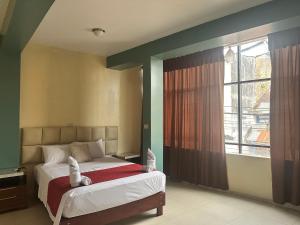 a bedroom with a bed and a large window at DORAL Inn in Iquitos