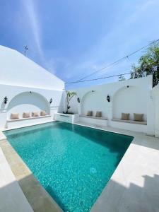 einen Pool in einem Haus mit blauem Wasser in der Unterkunft Ara Santvana Villa Bali in Legian