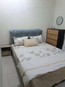 a bed with a blue headboard in a bedroom at Ed 01 sitiawan homestay in Sitiawan