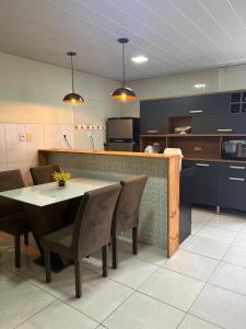 eine Küche mit Tisch und Stühlen und einer Theke in der Unterkunft Apartamento no coração de Maragogi in Maragogi
