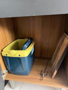 ein blauer und gelber Eimer auf einem Holzregal in der Unterkunft Apartamento no coração de Maragogi in Maragogi + 6 Fotos