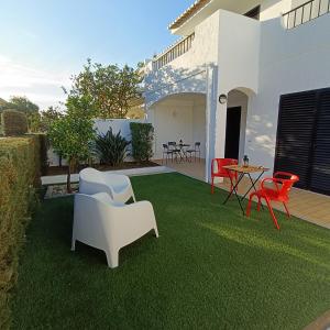 a lawn with chairs and a table on it at Lagos Charming Villas in Lagos