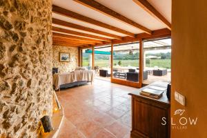 un salon avec un mur en pierre dans l'établissement Villa Son Bennasar by Slow Villas, à Felanitx 29 autres photos