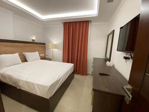 a hotel room with a bed and a flat screen tv at Grand Plaza Sheikh Zayed in Kafr Abū ʼumaydah +39 photos