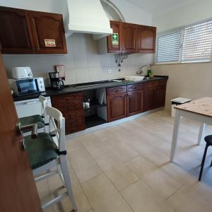 a kitchen with wooden cabinets and a table and a counter at Lagos Charming Villas in Lagos