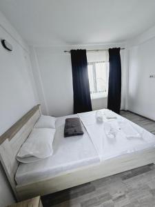 a large white bed in a room with a window at Comapart2 in Bacău