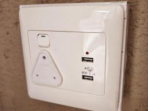 un interruptor de luz blanco en una pared en De Adelaar Landgoed, en Cullinan