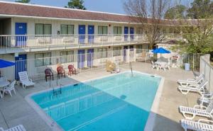 a pool in front of a hotel with chairs and umbrellas at Motel 6-Washington, DC in Washington