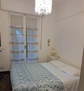 a bedroom with a bed and a chandelier and a window at Angolo Verde in Santa Margherita Ligure