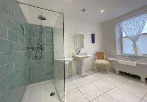a bathroom with a shower and a tub and a sink at 45 Eskin Street in Keswick +19 photos