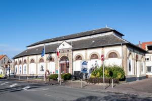 a building with flags in front of a street at Rosamel - Studio à 1km de la gare proche port in Étaples