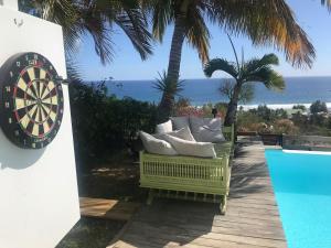 a room with a dart board next to a pool at Villa Alcazar - climatisée avec piscine, vue mer in La Possession
