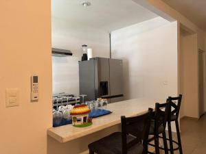 a kitchen with a table with chairs and a refrigerator at Casa Puerto Paraíso in Puerto Morelos