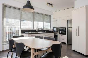 a kitchen with a wooden table and chairs at Best Location 3BR Specious Apartment By Vacay in Tel Aviv +13 photos