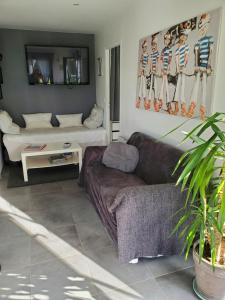 een woonkamer met een bank en een tafel bij LA GRIOTTE 3 LOFT & Spa in Pennedepie