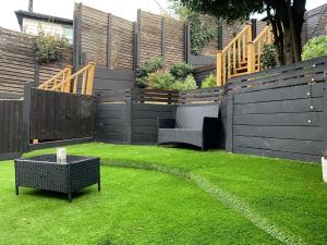a garden with two chairs and a table on the grass at Charming 2-Bedroom Maisonette in Leigh-on-Sea +6 photos