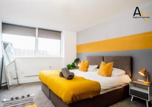 ein Schlafzimmer mit einem großen Bett mit gelben Kissen in der Unterkunft Special Offer - Bright 1BR Apartment with Free Parking & Fast Wi-Fi By AV Hughes Properties in Milton Keynes