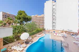 Una piscina con tumbonas y un hotel. en BLUESEA Arenal Tower Adults Only, en El Arenal