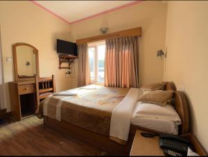 um quarto com uma cama grande e uma janela em Green Tara Hotel em Pokhara