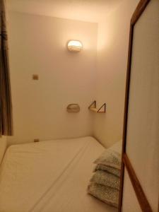 a small room with a bed and a mirror at Studio port, lac, plage in Talmont