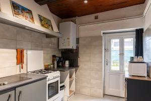 Una pequeña cocina con estufa y ventana. en Fête des Lumières Lyon Séjour à Montluel, en Montluel