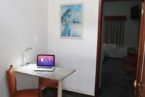 a laptop computer sitting on top of a table at ARQ Inn Hotel in Ribeirão Preto