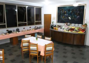 ein Esszimmer mit einem Tisch und einer Theke mit Speisen in der Unterkunft ARQ Inn Hotel in Ribeirão Preto