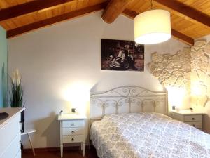 Un dormitorio con una cama blanca y una lámpara. en Oasi Azzurra - Cosy flat with a terrace and a great view over lake and mountains, en Fonteno