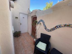 a room with a wall with a chair and a plant at La Tejita Studio in La Tejita